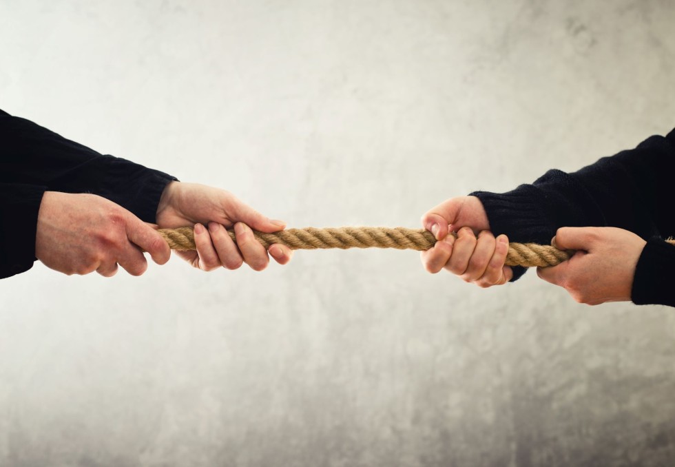 Deux hommes opposés tirant une corde.
